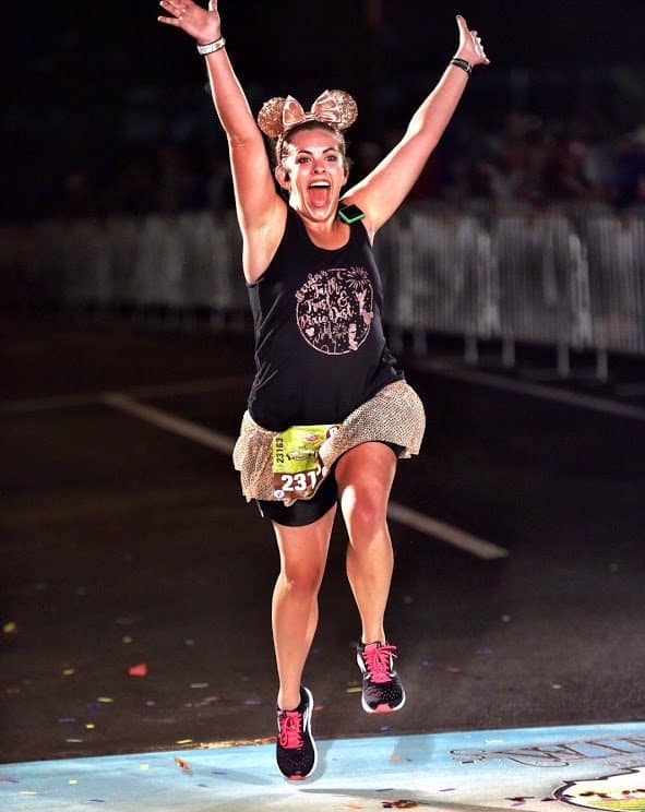 Sarah Bergman, a rundisney travel agent, crossing the finish line at a race
