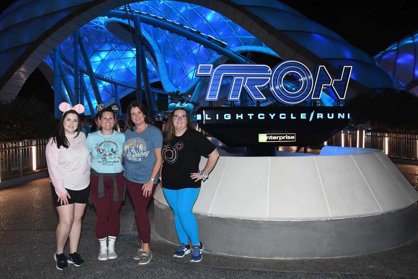 4 women standing in front of the TRON Lightcycle Run coaster at Walt Disney World. TRON review.