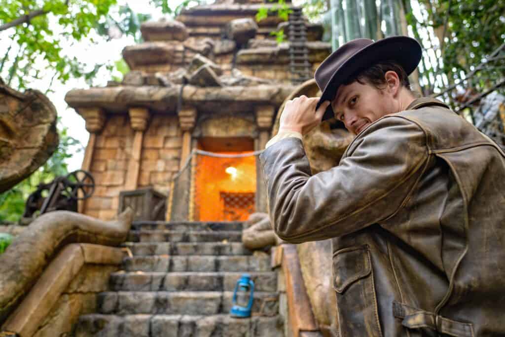 Indiana Jones meet and greet at Disneyland. Man in front of a temple wearing a fedora hat and tan bomber jacket. 