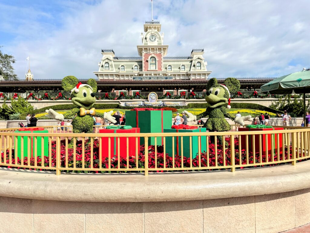 WHEN-DOES-DISNEY-WORLD-DECORATE-FOR-CHRISTMAS. Mickey and Minnie topiaries in Christmas outfits.